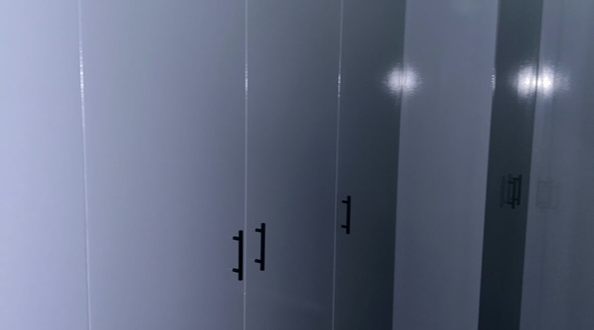 Clean, minimalist commercial or apartment hallway with light grey walls and dark trim, showcasing a professional interior paint finish by a painter melbourne.